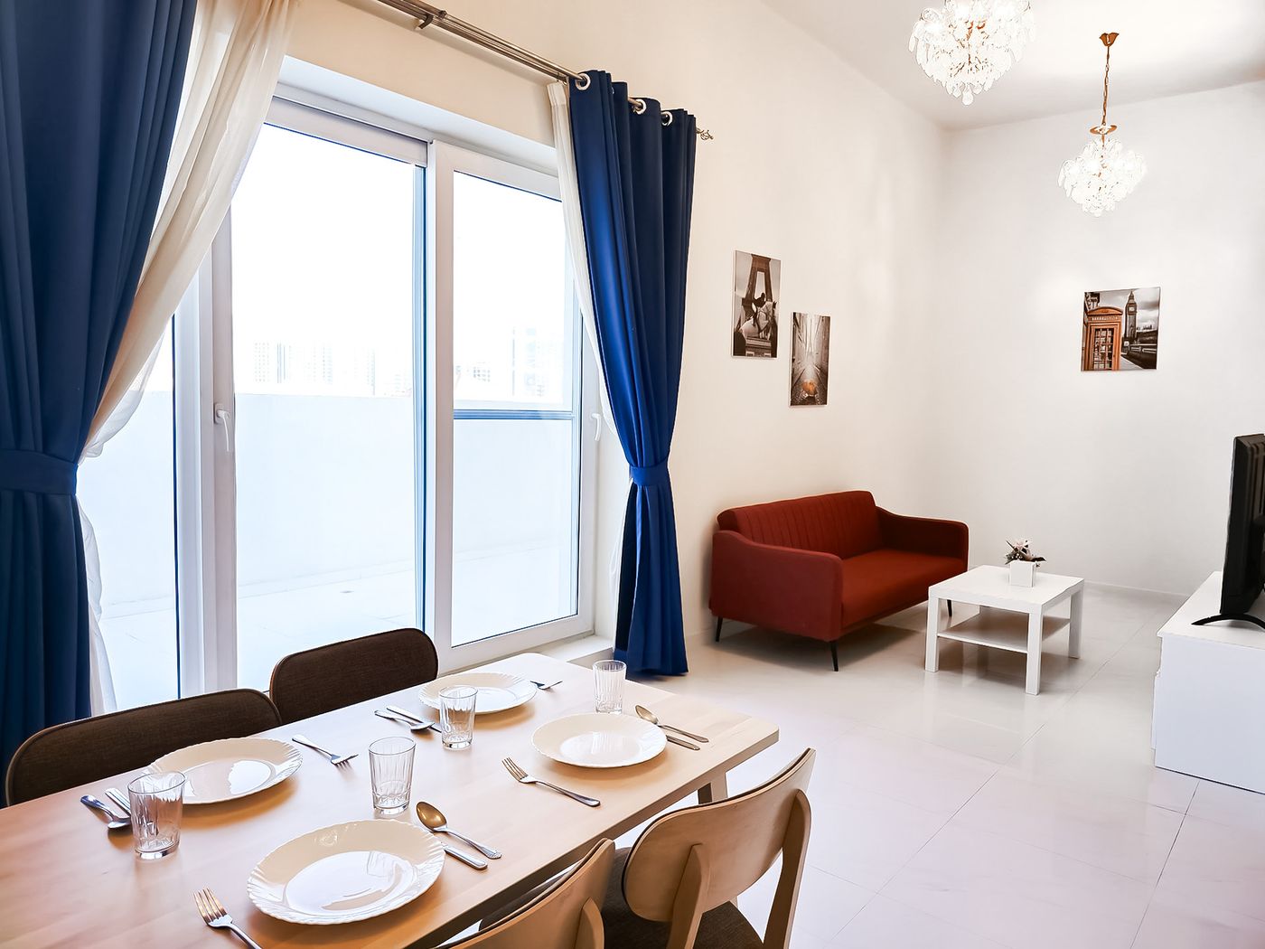 Two-bedroom apartment living and dining area with a red sofa and a table set for four